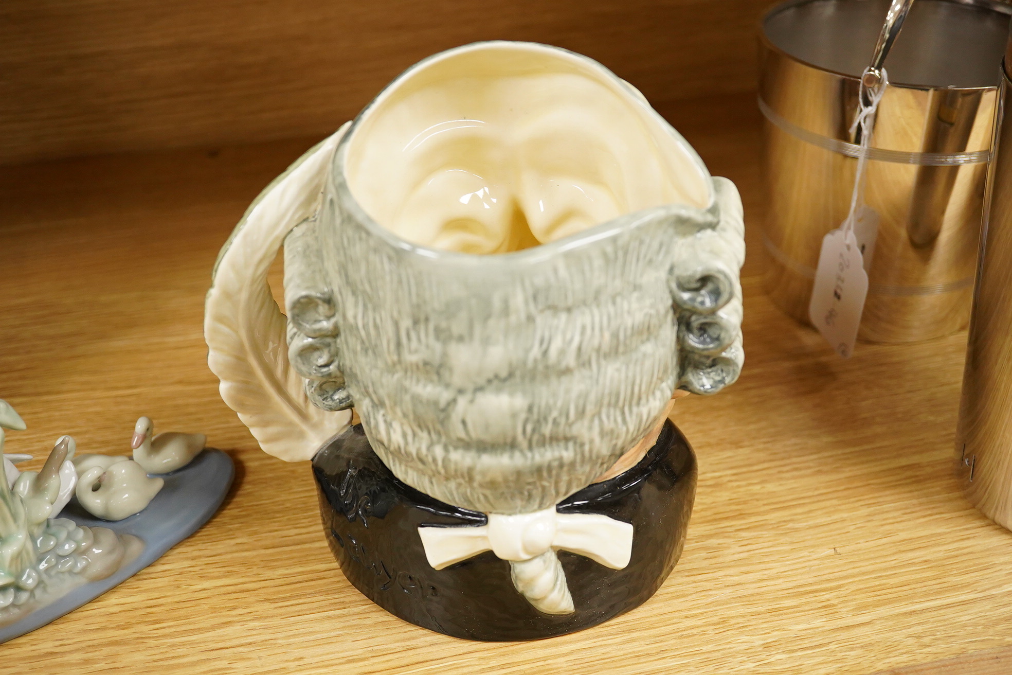 Four Lladro and Nao figures and a Doulton Toby jug, The Lawyer, largest 20cm high